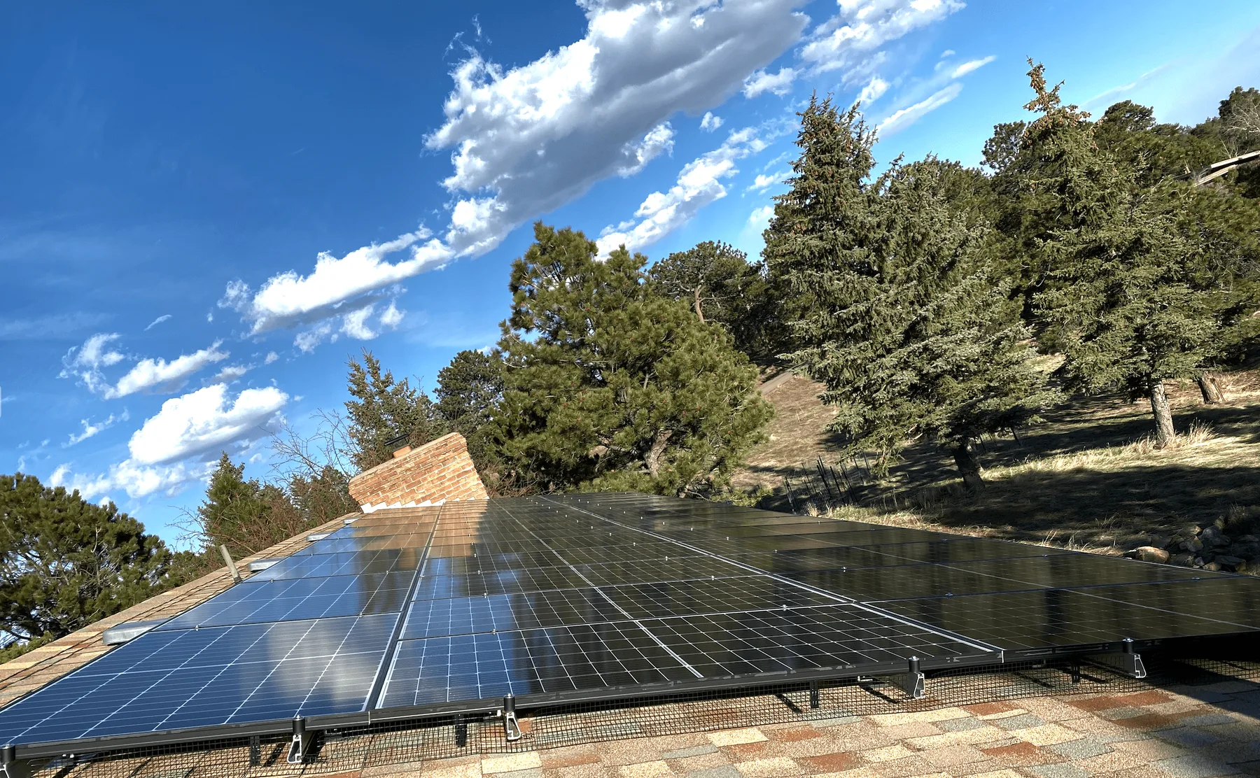 Mountain-home rooftop array among the pines